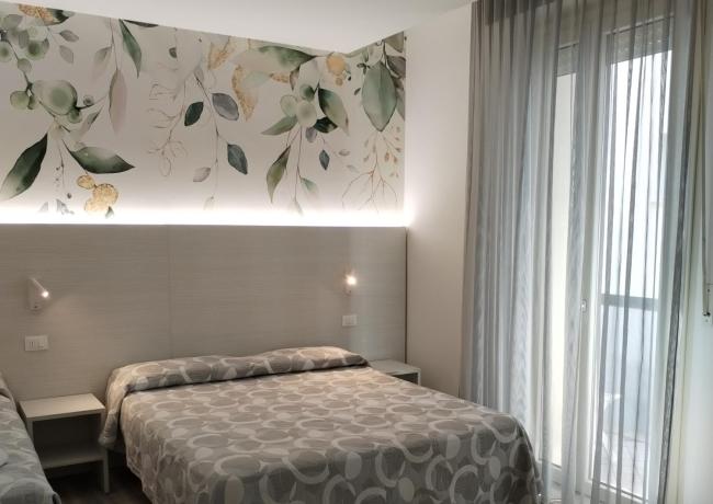 Modern room with double bed and floral decorations.