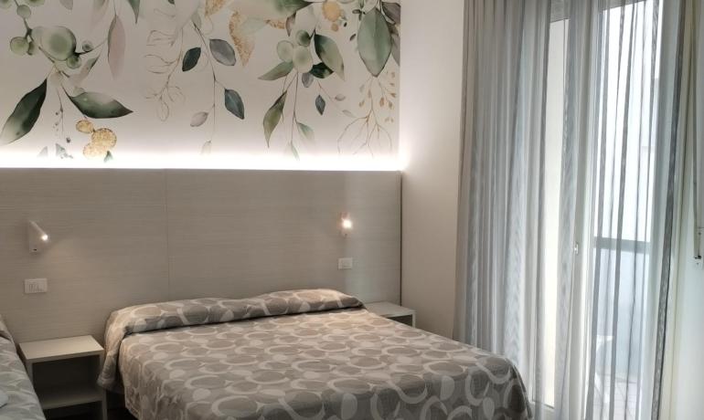 Chambre moderne avec lit double et décorations florales.