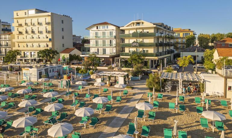 Beach with umbrellas and hotel in the background.