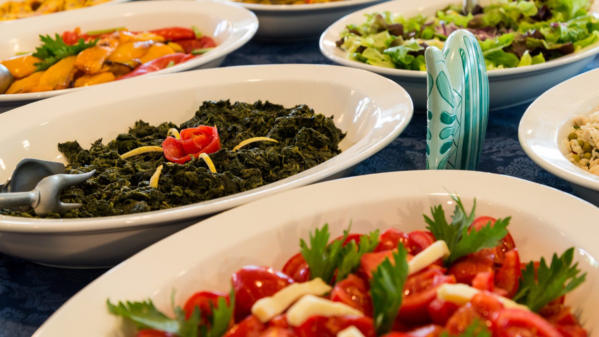 Varietà di piatti vegetariani colorati e freschi su un tavolo.