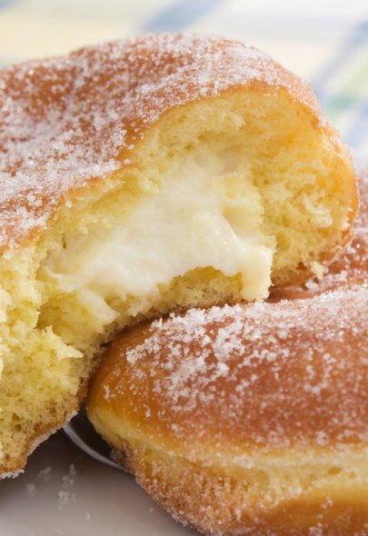 Bombolone alla crema ricoperto di zucchero, soffice e invitante.